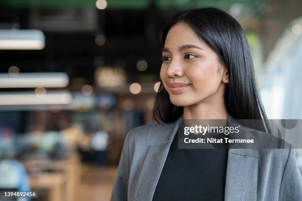 empower of businesswomen build and drive business continuity. portrait of young female businesswomen in a fin tech business office while looking away. she is expert in financial management by using technology. - customer profile stock pictures, royalty-free photos & images