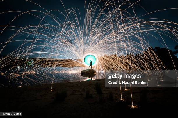 dynamic sparks flying out over a man standing on a rock - land speed stockfoto's en -beelden