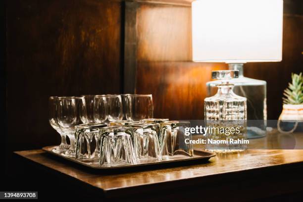 vintage-style whiskey decanter and serving glasses on a wooden bar counter - side table stock pictures, royalty-free photos & images