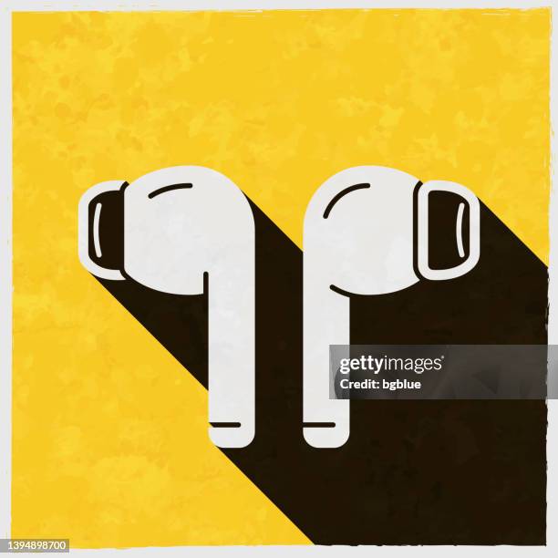 wireless earphones. icon with long shadow on textured yellow background - wireless earbuds vector stock illustrations