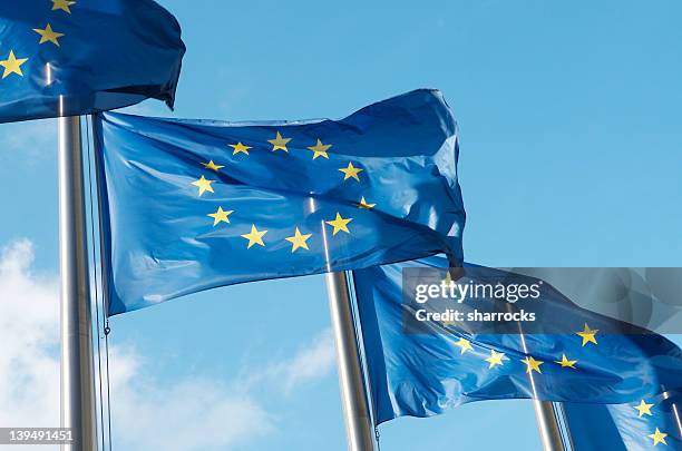 four european union flags waving in the wind - european flag stockfoto's en -beelden