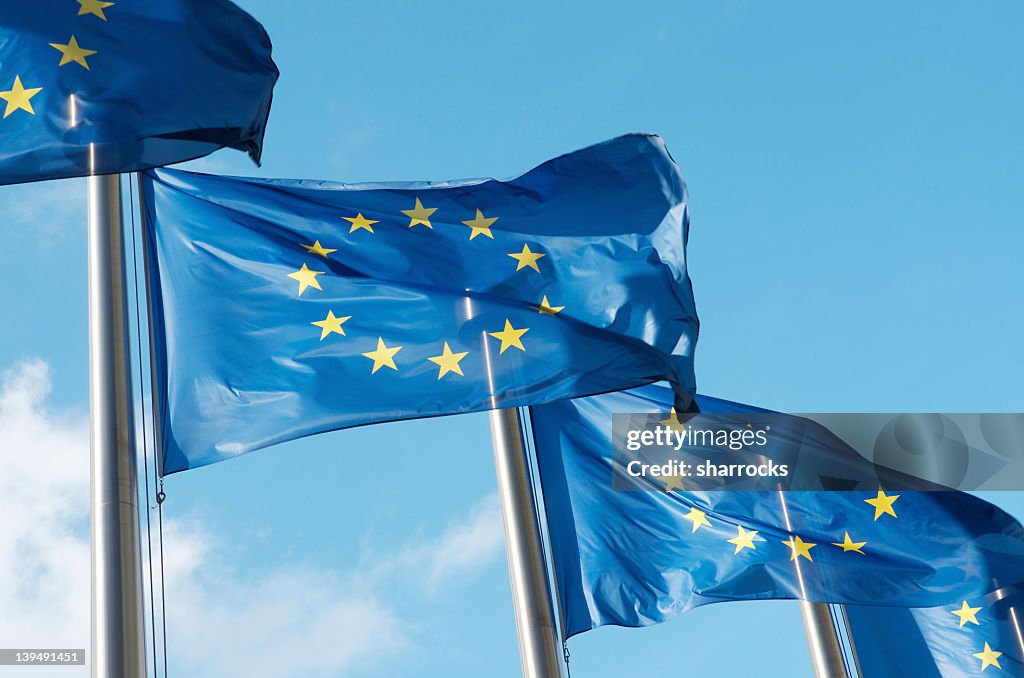 Four European Union flags waving in the wind