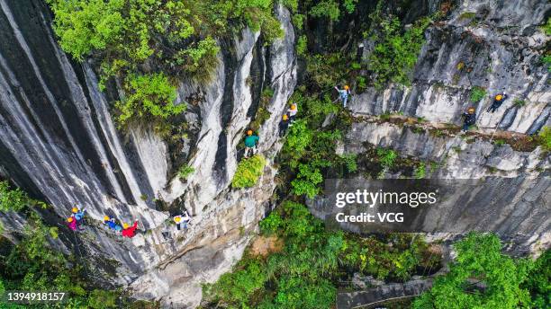 Tourists experience rock climbing at a scenic area during the May Day holiday on May 1, 2022 in Yibin, Sichuan Province of China.