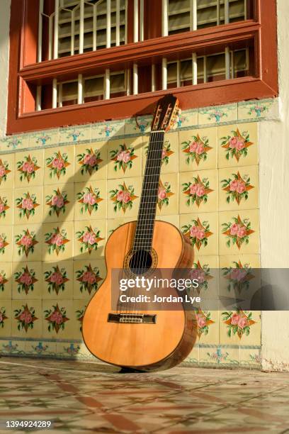 classical guitar on an antique tiles wall - guitar neck stock pictures, royalty-free photos & images