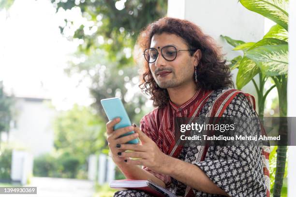 transgender non-binary person using a mobile phone. - transgender stock pictures, royalty-free photos & images