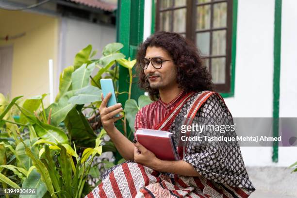 transgender non-binary person using a mobile phone. - indian transgender stock pictures, royalty-free photos & images