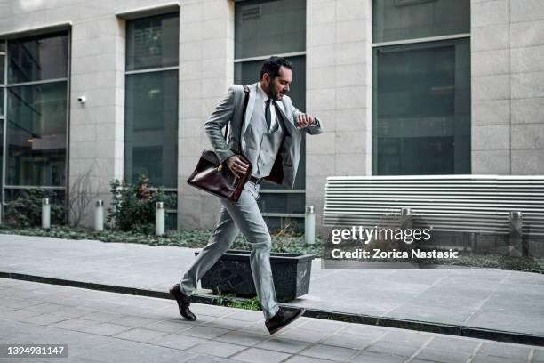 uomo d'affari che arriva tardi al lavoro - urgenza foto e immagini stock