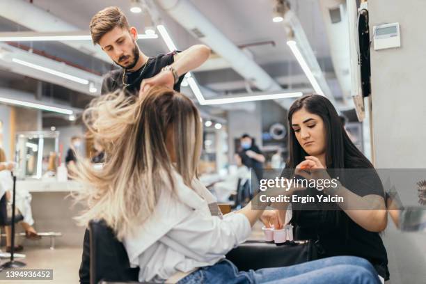 jeune femme sous traitement de manucure au salon de beauté - salon de beauté photos et images de collection