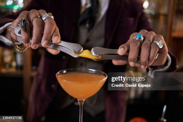 unrecognizable bartender squeezing lemon into cocktail - bartender bildbanksfoton och bilder