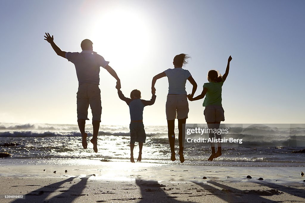 Family jumping together on a beach