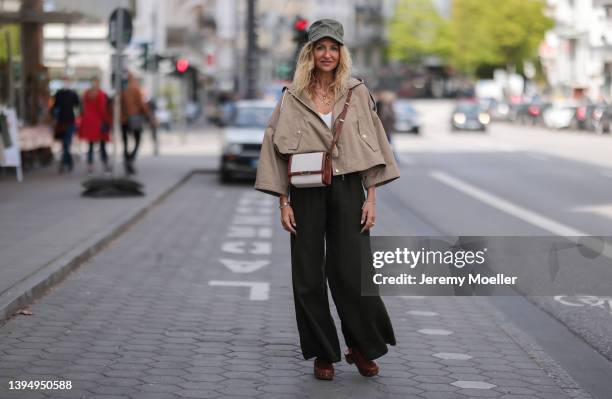 Sue Giers seen wearing a pale green Celine hat, a beige cropped trench jacket from Celine, a white top from SoSue, a black wide leg pants from SoSue,...