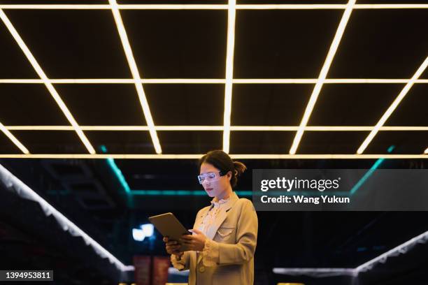 young business woman wearing augmented reality glasses using tablet at night - ai - fotografias e filmes do acervo