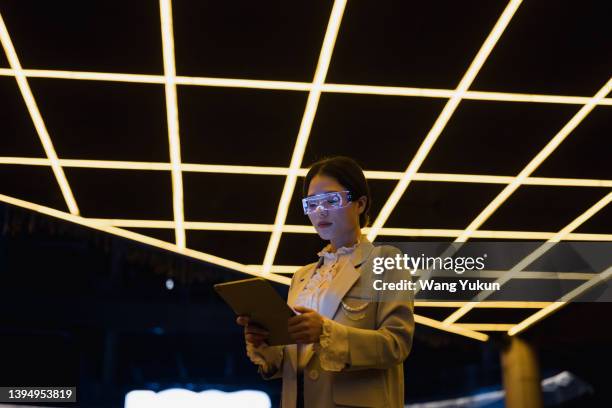 young business woman wearing augmented reality glasses using tablet at night - big tech stock pictures, royalty-free photos & images