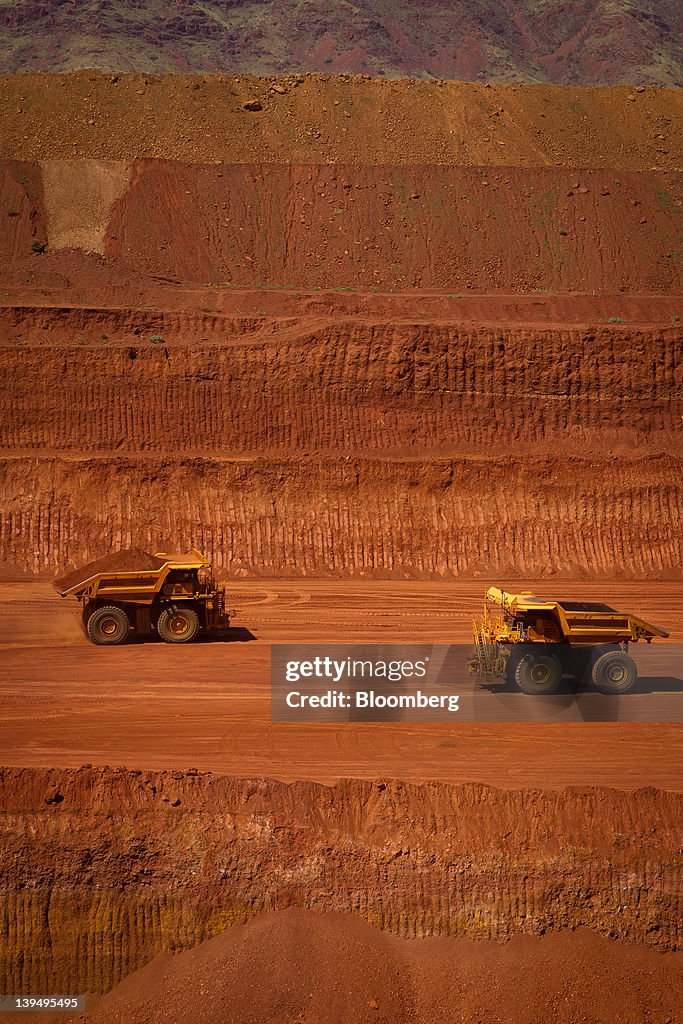 Pit Tech Rio Tinto Autonomous haul trucks drive through a pit at Rio Tinto Group's West ...
