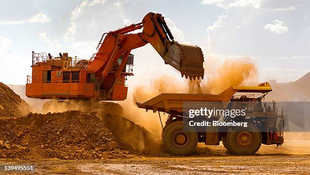 Haul truck is loaded by a digger with material from the pit at Rio Tinto Group's West Angelas iron ore mine in Pilbara, Australia, on Sunday, Feb....