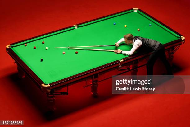 Judd Trump of England plays a shot during the Betfred World Snooker Championship Final match between Judd Trump of England and Ronnie O'Sullivan of...