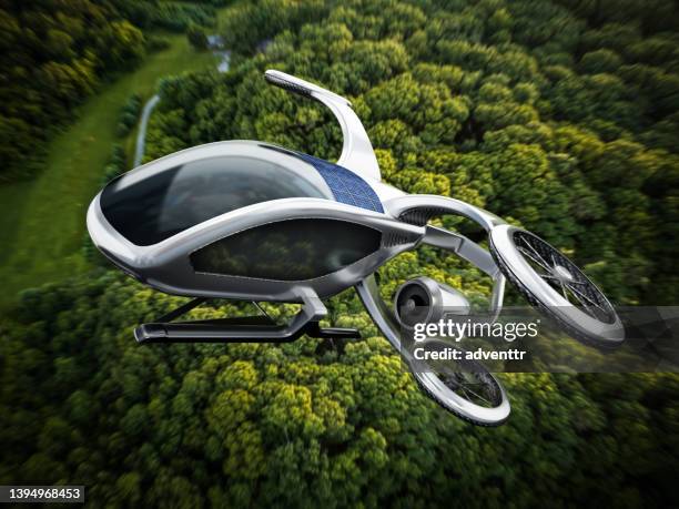 konzeptionelles evtol (elektrisches vertikales starten und landen) flugzeug, das vor einem dichten waldhintergrund fliegt - flying cars stock-fotos und bilder