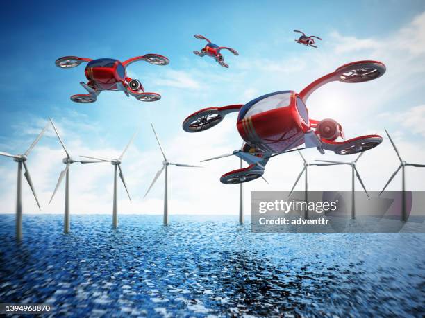 conceptual evtol (electric vertical take-off and landing) aircrafts flying over the sea and wind turbines - flying cars stockfoto's en -beelden