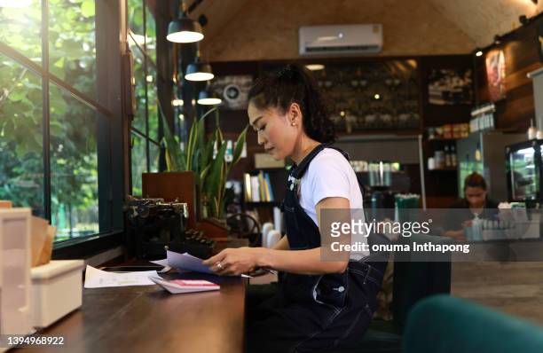 female owner concentration working in coffee shop, small business concept - small restaurant stock pictures, royalty-free photos & images