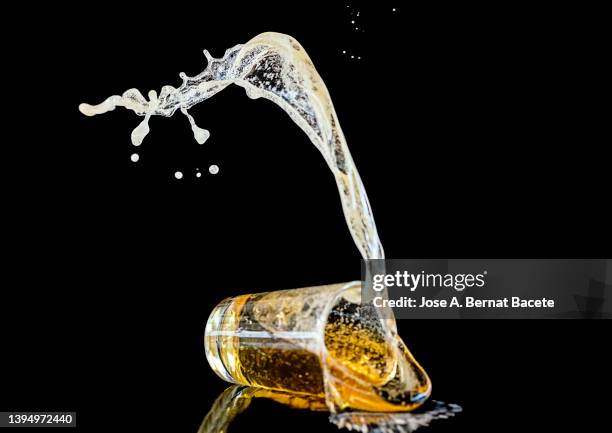 impact of a glass with beer falling to the ground on a black background. - beer glass stock pictures, royalty-free photos & images