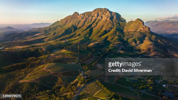An evening aerial view of the Simonsberg Mountain with its surrounding farms and wine estates on March 14, 2022 in the Western Cape wine-producing...