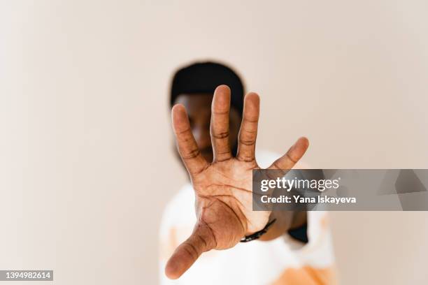 man with dark skin tone reaching out to the camera with an open hand - digital fingerprint stock pictures, royalty-free photos & images