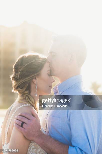 beautiful bride and groom kissing at their destination wedding outdoors in an affectionate portrait - first kiss imagens e fotografias de stock