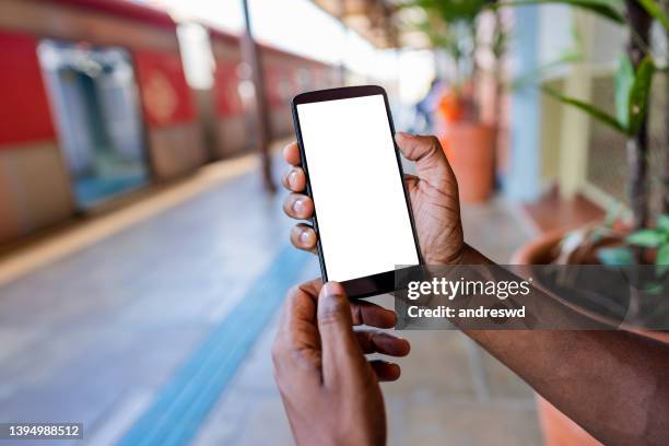 man using smartphone at subway station - man holding his hand out stockfoto's en -beelden