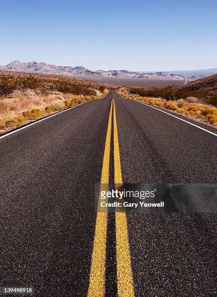 desert road leading into the distance - single yellow line stock pictures, royalty-free photos & images
