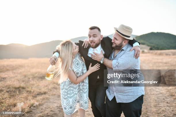 best man getting drunk and carried by guests - wedding people stock pictures, royalty-free photos & images