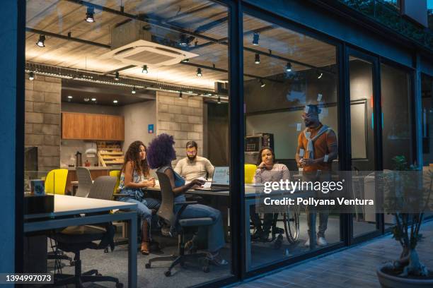 people working in creative office at night - start up office stock pictures, royalty-free photos & images