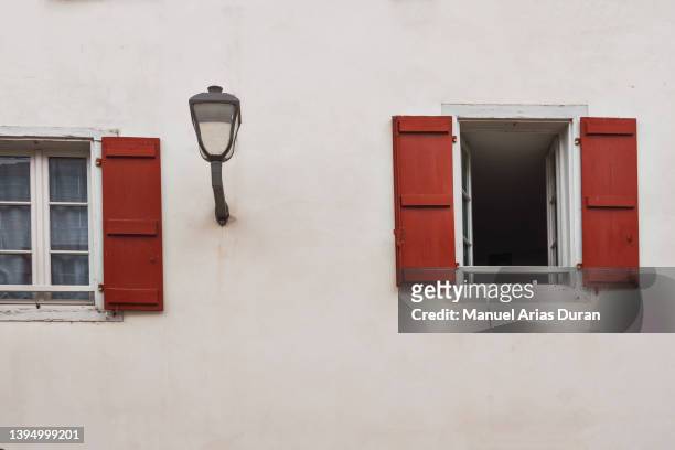 white facade with red wooden windows. - espelette france imagens e fotografias de stock