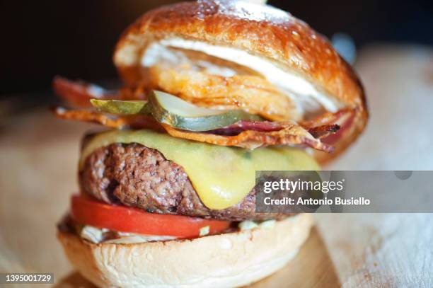 close up image of cheeseburger with fried onion ring and bacon - large cucumber stockfoto's en -beelden
