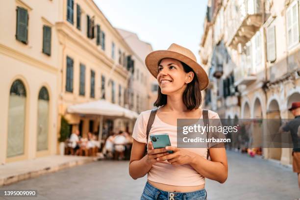 junge touristin, die die griechische architektur genießt - greek woman stock-fotos und bilder