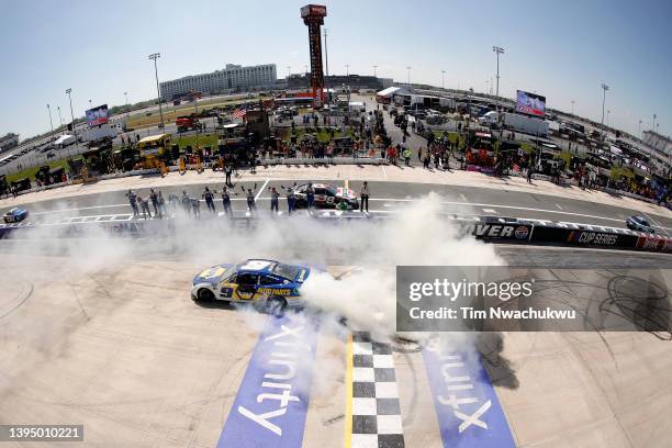 Chase Elliott, driver of the NAPA Auto Parts Chevrolet, celebrates with a burnout after winning the NASCAR Cup Series DuraMAX Drydene 400 presented...