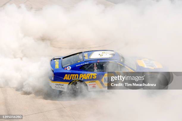 Chase Elliott, driver of the NAPA Auto Parts Chevrolet, celebrates with a burnout after winning the NASCAR Cup Series DuraMAX Drydene 400 presented...