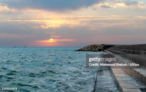 scenic view of sea against sky during sunset - groyne photos et images de collection