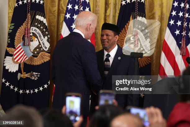 President Joe Biden greets Talib Shareef Imam of Masjid Muhammad, also known as The Nation’s Mosque, during an Eid al-Fitr reception at the East Room...