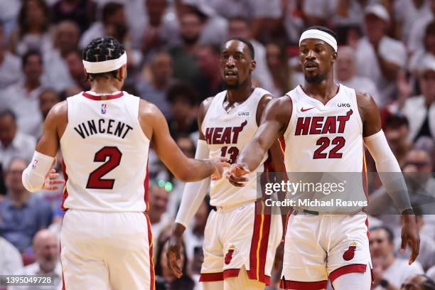 Gabe Vincent and Jimmy Butler of the Miami Heat high five against the Philadelphia 76ers during the first half in Game One of the Eastern Conference...