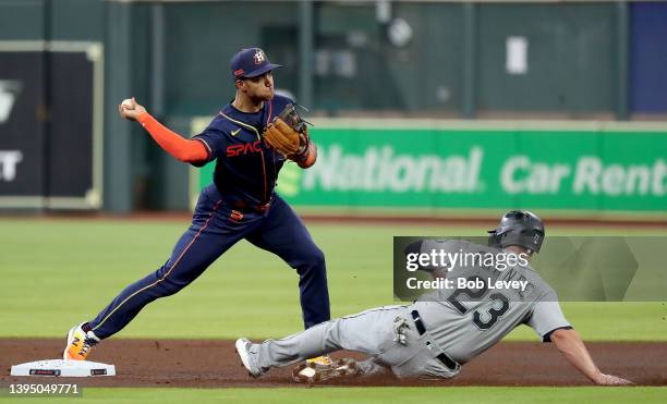 Jeremy Pena of the Houston Astros turns a double play at second base over Ty France of the Seattle Mariners in the first inning at Minute Maid Park...