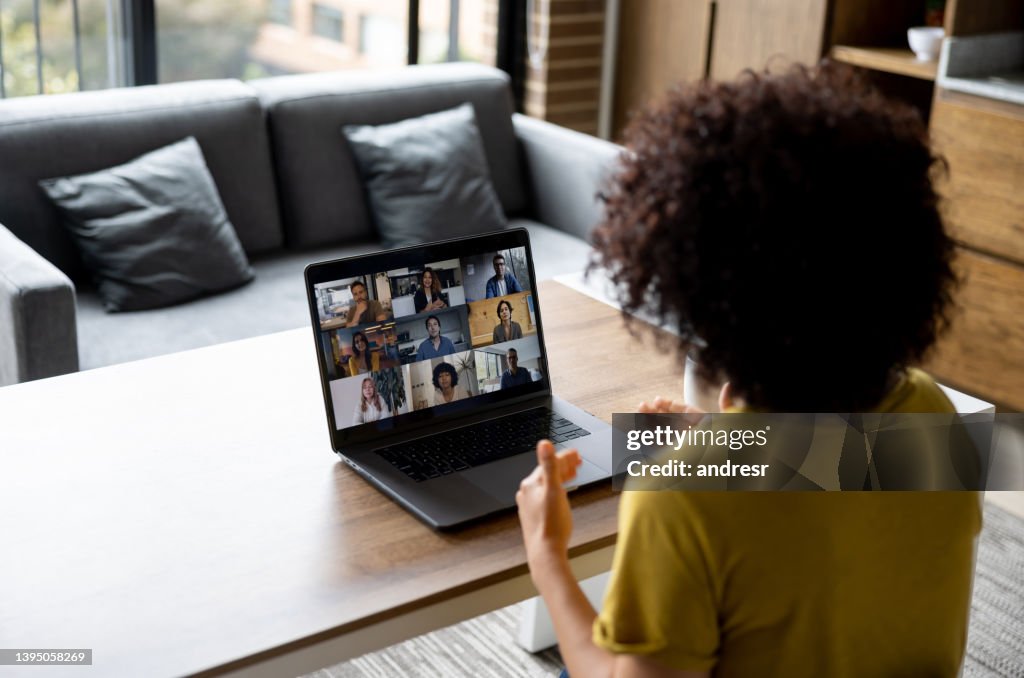 Femme parlant à des collègues lors d’une réunion d’affaires en ligne tout en travaillant à la maison