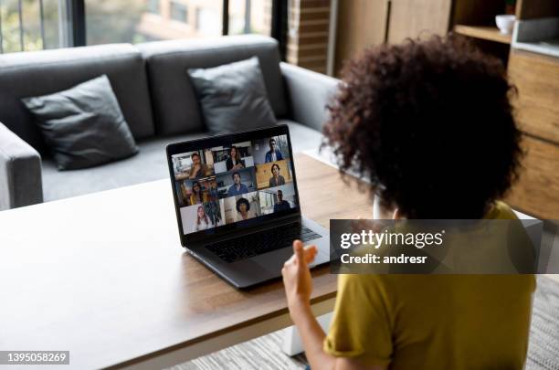 woman talking to some colleagues in an online business meeting while working at home - zoom video conference stock pictures, royalty-free photos & images