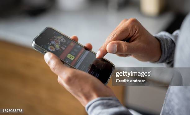 close-up on a man betting online on a sports app in his cell phone - gaming imagens e fotografias de stock