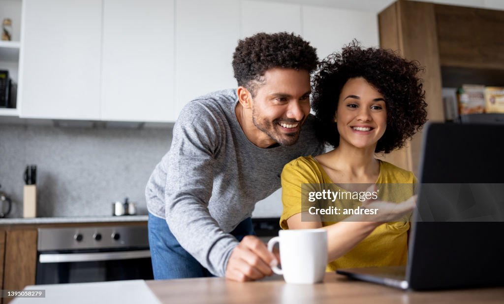 Couple at home making a reservation online using their laptop