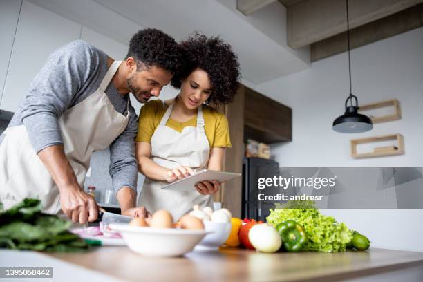 couple cooking together at home following an online recipe - following recipe stock pictures, royalty-free photos & images