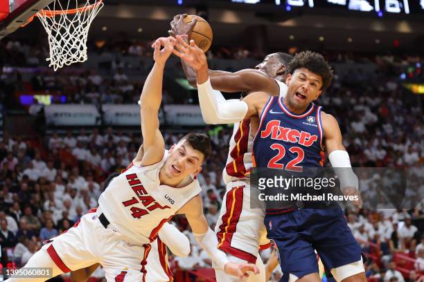 Tyler Herro and Bam Adebayo of the Miami Heat battle for a rebound with Matisse Thybulle of the Philadelphia 76ers during the first half in Game One...
