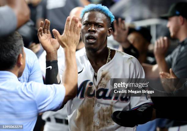 Jazz Chisholm Jr. #2 of the Miami Marlins high fives teammates after scoring a run against the Arizona Diamondbacks during the seventh inning at...