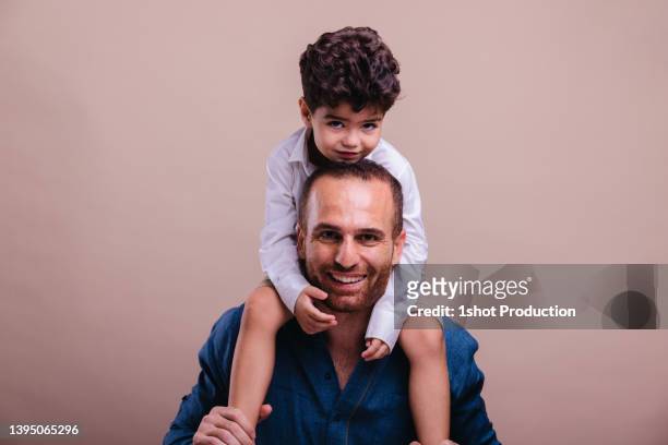 familienporträt des nahen ostens, huckepack zurück. - two young arabic children only indoor portrait stock-fotos und bilder