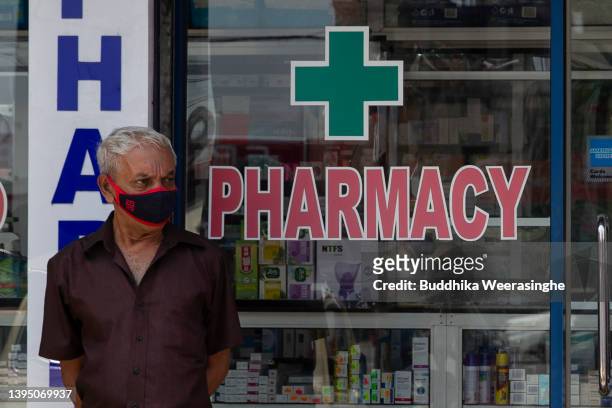 Man stands outside the drug store on May 02, 2022 in Colombo, Sri Lanka. Sri Lankan nation is facing its worst financial crisis since gaining...
