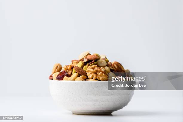 mix nuts and dry fruits in a bowl with white background - bowl 個照片及圖片檔